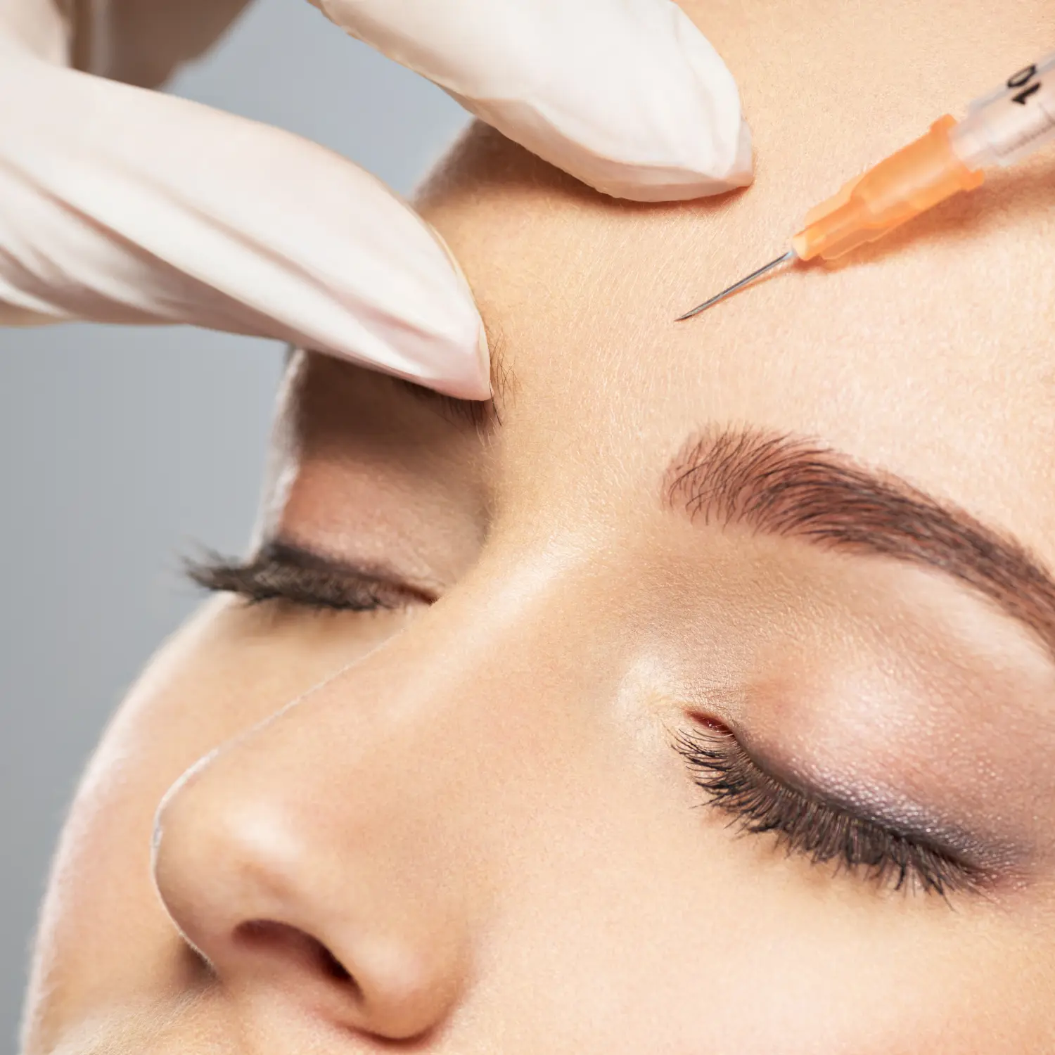 Frau bekommt kosmetische Botox-Injektion in Augennähe